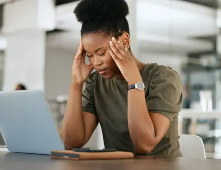 194843346 stress headache and black woman with laptop in office tired exhausted and worry from overworked